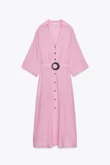 Vestido camisero midi a rayas verticales rosas y blancas, confeccionado en lino. Tiene cuello solapa, escote pico, manga corta con vuelta y cinturón con hebilla redonda negra. Cierre frontal con botones y bolsillos laterales ocultos en costura.