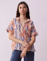 Blusa de gasa bambula estampada con cuello con solapa, escote en V y botón. Tiene un bolsillo aplicado en la parte delantera.