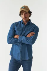 Camisa de jean azul de manga larga con dos bolsillos frontales con solapa abotonada.