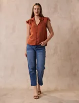 Camisa azul de satén, marca Alex & Lili. Cuello a la base con solapa, escote en V, apertura central con botones y sisa con volados.