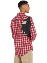 Riñonera Tommy Jeans Essential bicolor negra y beige con logo de la marca en el frente, bolsillo frontal con cierre y correa ajustable con inscripción de la marca. Capacidad de 2 litros.