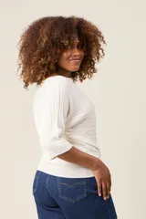 Blusa color rosa claro de hilo con textura acanalada horizontal, escote bote y mangas 3/4. Corte holgado.