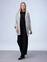 Blazer de tejido tweed con cuello solapa, abertura central y bolsillos aplicados, acabado desflecado.