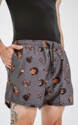 Short de baño gris con estampado de estilo tatuaje en tonos naranja y negro, con cintura elástica y cordón ajustable. Cuenta con cuatro bolsillos y está confeccionado en textil plano liviano de secado rápido.