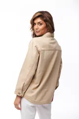Sobrecamisa de jean color beige, con cuello clásico, cierre frontal con botones y dos bolsillos de parche en el pecho.