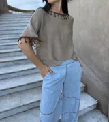 Remera tejida color marrón con hilado 100% algodón y cintas de piedras aplicadas en cuello y mangas.