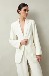 Blazer color crema a rayas verticales finas, de corte recto y solapas clásicas.