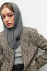 Balaclava tejida gris melange con capucha y cordones ajustables.