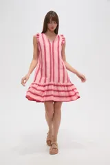 Vestido corto de viscosa con estampado a rayas verticales azules y amarillas, escote en V y volados en los hombros. Tiene corte holgado y falda con volantes.