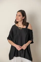 Blusa italiana gris de viscosa, lisa, con corte irregular y un hombro descubierto. De calce holgado.