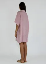 Vestido corto tipo camisola, color blanco, con cuello camisero, mangas cortas y bolsillo de parche con detalle de calado.