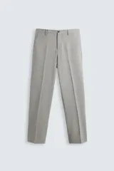 Pantalón de vestir gris claro, de corte recto, confeccionado en tejido con lana. Cuenta con bolsillos frontales y traseros de doble vivo con botón. Cierre frontal con cremallera y botón.