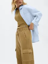 Pantalón cargo color marrón claro, de corte ancho, con bolsillos laterales con solapa y cintura ajustable con cordón.