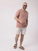 Remera de algodón color rosa viejo, con cuello henley de tres botones y mangas cortas.