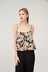 Musculosa con estampado floral multicolor sobre fondo negro, breteles anchos y escote cuadrado.