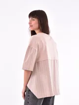 Remera de color beige con mangas a rayas y corte holgado.