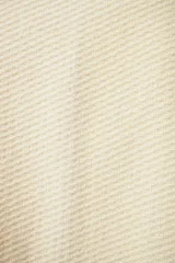 Chaleco color crema de lana sin teñir, corte recto, con cuello y solapa pronunciadas, broches a presión y bolsillos ojal.