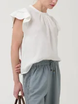 Blusa blanca de algodón orgánico y ramie, con mangas cortas con detalle de crochet y cuello redondo.