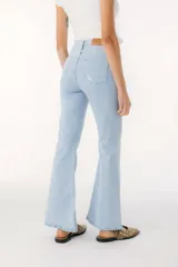 Pantalón de jean azul de corte acampanado con aberturas en el ruedo.