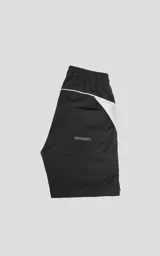 Bermuda negra con recortes blancos, calce oversize, textil liviano, elástico en la cintura, cordón de ajuste, bolsillos delanteros y traseros.