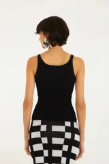 Top negro de punto acanalado con tirantes finos y logo estampado en el pecho.