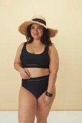 Top de bikini negro con breteles finos y detalle de calado horizontal debajo del busto.
