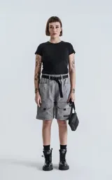 Bermuda cargo color gris oscuro (carbón), de corte recto y largo hasta la rodilla, con cinturón de cinta negra ajustable con hebilla de plástico. Presenta bolsillos laterales y bolsillos cargo con solapa en las piernas.