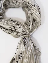 Pañuelo de satén color gris con estampado de flores blancas y negras.