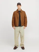 Campera marrón de algodón con cuello clásico, cierre frontal con cremallera y bolsillos laterales.