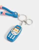 Llavero con dije de celular azul con detalles en amarillo y blanco. Incluye un strap con forma de gusano azul con detalles de estrellas y círculos de colores.
