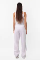 Pantalón sastrero recto de poplín color blanco, tiro medio-bajo, con cintura ancha, doble botón a tono y cierre metálico.
