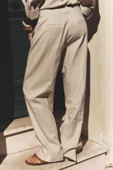 Pantalón marrón de lino, de tiro alto, con bolsillos delanteros y traseros.