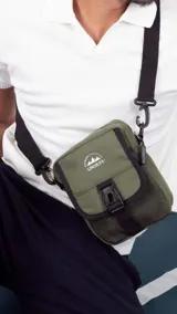 Morral verde militar con cierre, bolsillo delantero con presilla y broche de plástico, bolsillos internos y correa larga regulable.