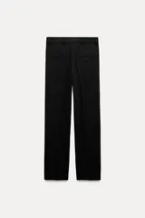 Pantalón negro de tiro bajo con trabillas en la cintura. Cuenta con bolsillos laterales y de vivo en la espalda, detalle de raya planchada en el delantero y cierre frontal con cremallera, botón y gancho metálico.