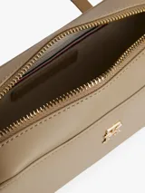 Bandolera Tommy Hilfiger color beige con logo dorado en el frente.