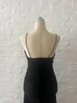 Vestido corto negro de microtul con escote en V y breteles finos.