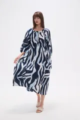 Vestido midi holgado con estampado abstracto en tonos azul marino, azul claro y blanco. Presenta cuello mao, botones frontales y cordón ajustable en la cintura.