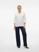 Camisa blanca de mangas largas con vuelta, cuello clásico, cierre frontal con botones y dos bolsillos con solapa en el pecho.