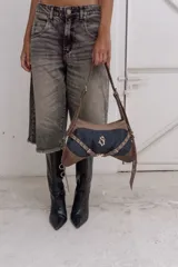 Cartera bandolera de gabardina y cuero color denim azul y cuero chocolate, con correa regulable para usar al hombro.
