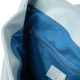Mochila celeste de símil cuero acolchado, con acceso mediante solapa con botones imantados. Tiene un compartimento principal con dos bolsillos abiertos y uno con cierre. Cuenta con correa regulable y herrajes plateados.