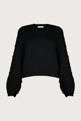 Suéter negro de tejido suave y esponjoso con diseño relajado. Tiene cuello redondo, mangas amplias con volumen y acabado acanalado.