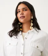 Camisa blanca de manga larga con cuello camisero, cierre frontal con botones a tono, dos bolsillos con solapa en el pecho y puños con trabilla.