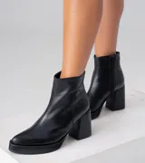 Bota corta negra de cuero vacuno, con taco de madera de 9 cm y plataforma delantera de 2 cm.