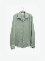 Camisa celeste de lino, de manga larga con botones de coco y parche de la marca.