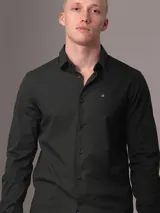 Camisa de vestir verde oscuro de popelín de algodón elástico, corte slim, con cierre frontal de botones y logo CK bordado en el pecho.