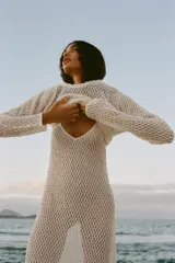 Top color crudo de tejido crochet calado, con cuello redondo y mangas largas.