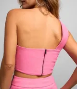 Blusa de fiesta color fucsia, de un solo hombro, confeccionada en bengalina con pliegues diagonales asimétricos.