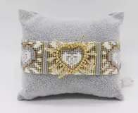 Set de pulseras tejidas con cuentas de colores y dije de corazón dorado.