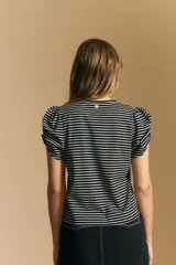 Remera de manga corta con rayas horizontales negras y blancas. Presenta cuello redondo y mangas abullonadas con frunce en los hombros.