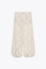 Pantalón bombacho de encaje color crudo, tiro alto, cintura elástica y forro interior.